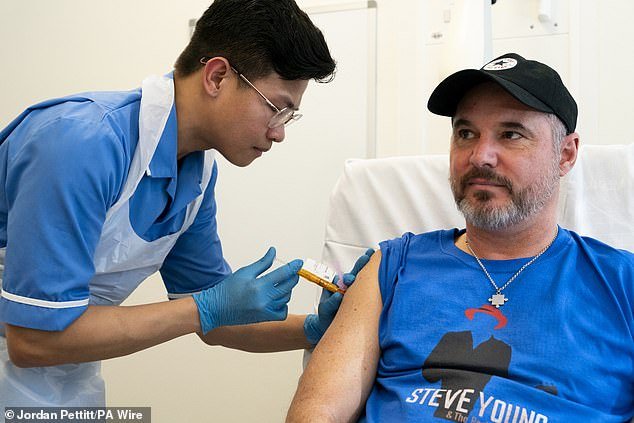 Nurse Christian Medina gives patient Steve Young his first jab at University College London Hospital