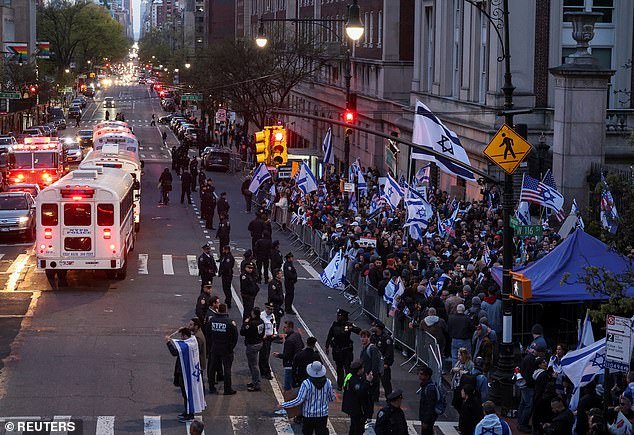 NYPD officers watch as people demonstrate in support of Israel outside the Columbia University campus, amid the student protest camp in support of the Palestinians