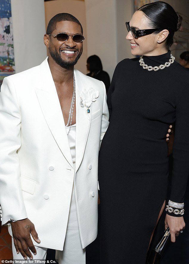 Gal beamed as she chatted with Usher, who modeled a white suit over a matching top that tantalizingly dipped down to reveal his toned chest