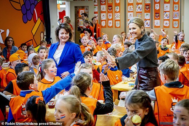The Dutch Royal, 52, appeared to be having a great time as she gave high fives and chatted with students