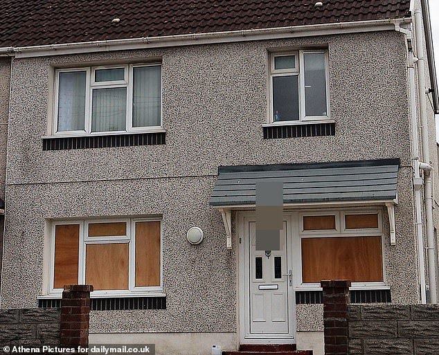 The boarded up windows of the Port Talbot house where a masked gang struck and smashed the windows of the suspected thieves