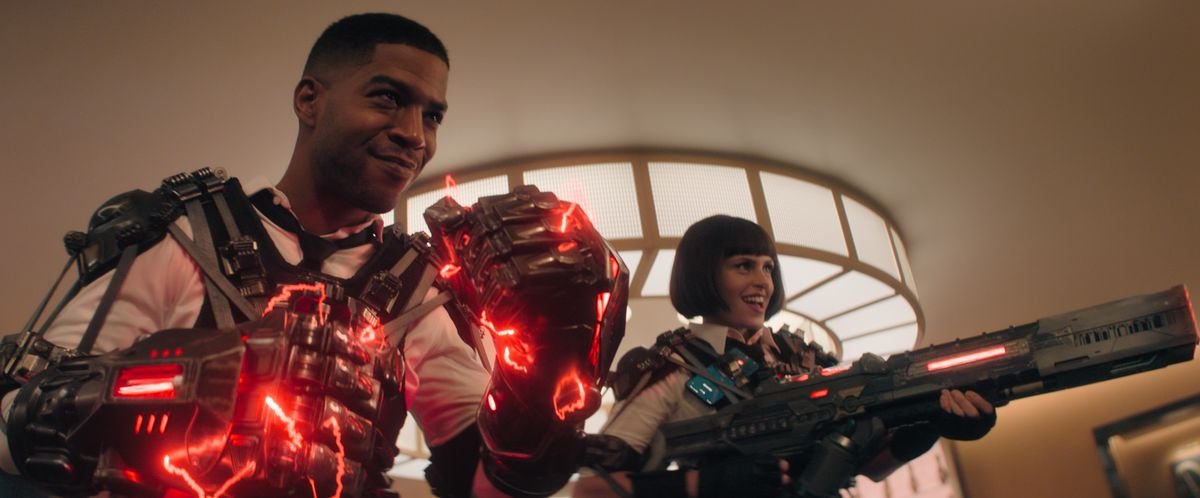Scott Mescudi as Agent Mason and Ellie Taylor as Agent Willoughby in Knuckles, standing with supercharged red energy gloves and a giant gun