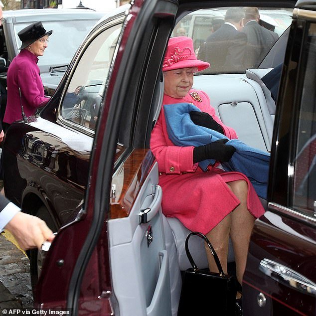 Queen Elizabeth appears to quickly cover her legs with a blanket as her car door opens