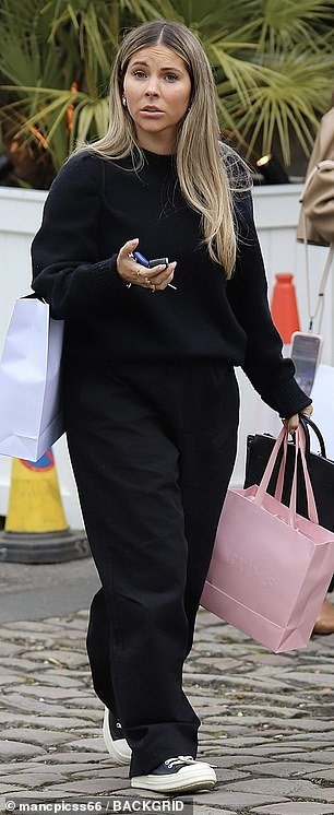 Luke Shaw's long-term girlfriend Anouska kept it casual and opted for a simple black tracksuit and black Converse.