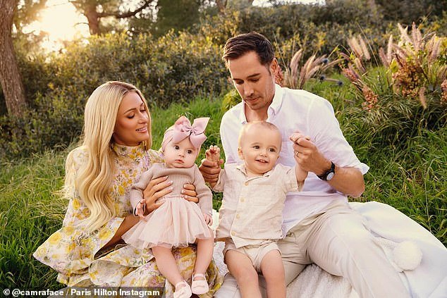 The socialite, 43, who welcomed London via surrogate in November, posed with husband Carter, 43, and son Phoenix, 15 months, in the first snaps captured by CamraFace