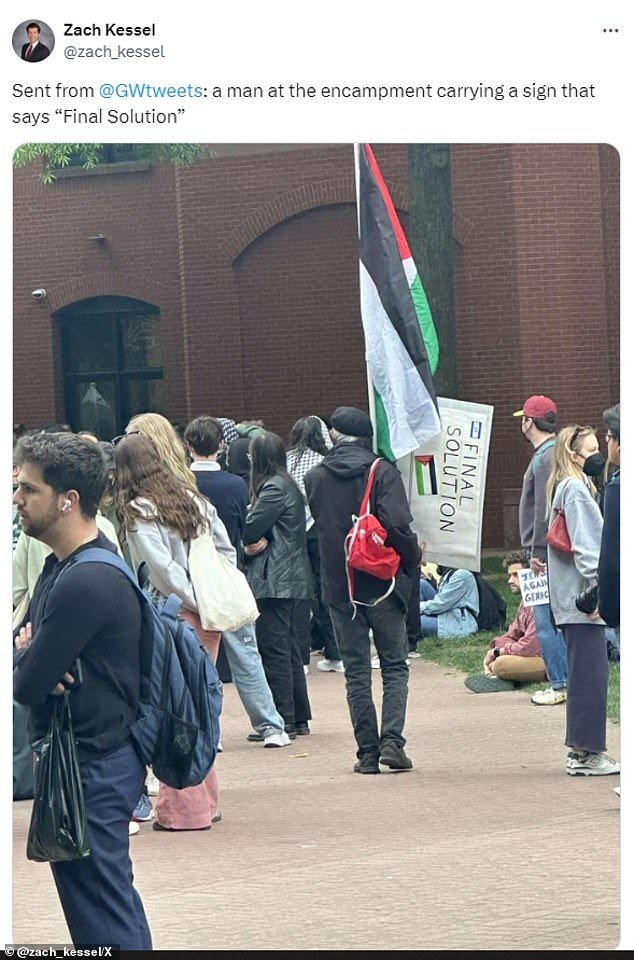 A protester at George Washington University (GWU) was seen on Thursday holding a sign calling for the 