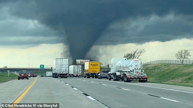 Storm chasers also documented a tornado crossing a highway near Omaha, revealing the funnel-shaped storm's destructive power.
