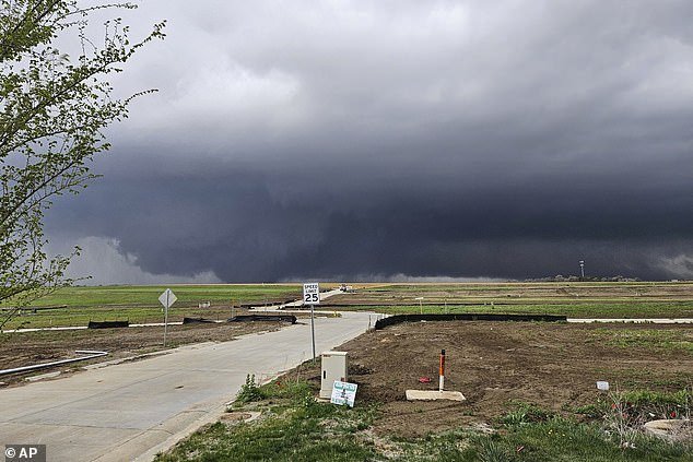 Heavy thunderstorm clouds appear as a tornado moves through the suburbs northwest of Omaha