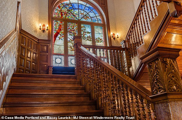 Here you can see a grand staircase, complete with intricate carvings, with beautiful stained glass windows