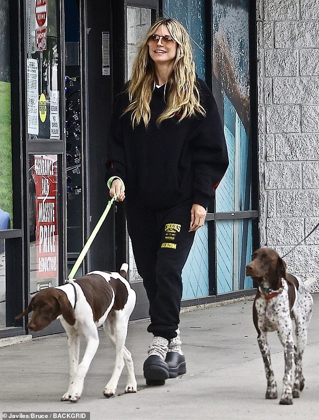The legendary supermodel stepped out with her husband and their two four-legged friends in a black tracksuit and matching Klogs with chunky socks