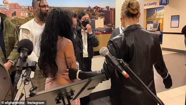 The activist appeared at the press conference on Friday in a very tight bodycon dress with daring cutouts to strengthen her position and beg for her job back.  She explained that the vandalized flag she was posing for was 