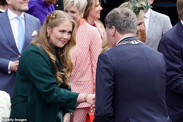 Princess Amalia shakes hands with a visitor during King's Day celebrations