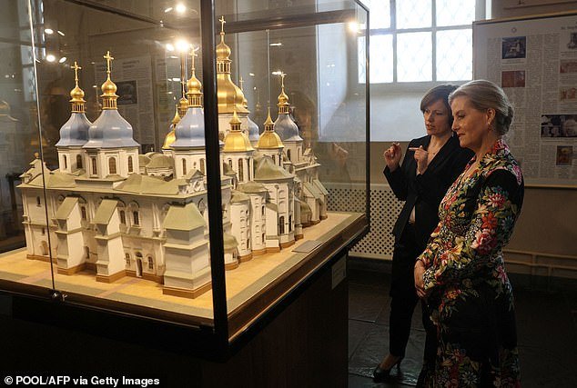 A guide shows Sophie a model of St. Sophia's Cathedral during a tour of the religious complex