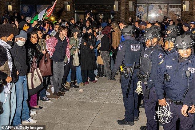 NYPD officers are confronted by protesters after detaining demonstrators and clearing a camp set up by pro-Palestinian students and demonstrators on the New York University campus
