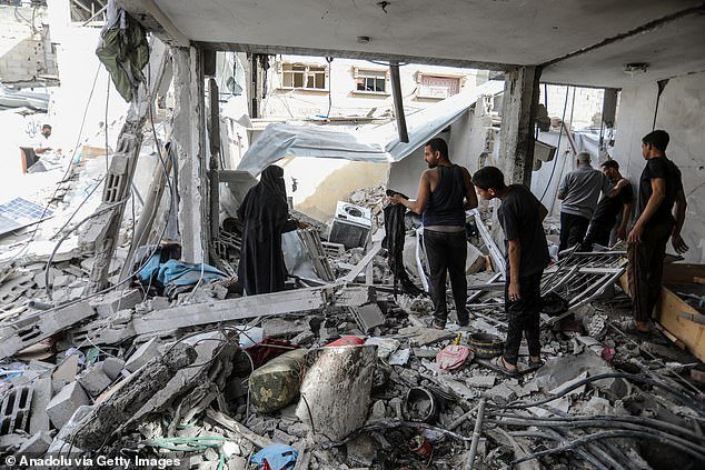 Palestinian residents of Gaza investigate the aftermath of an Israeli attack