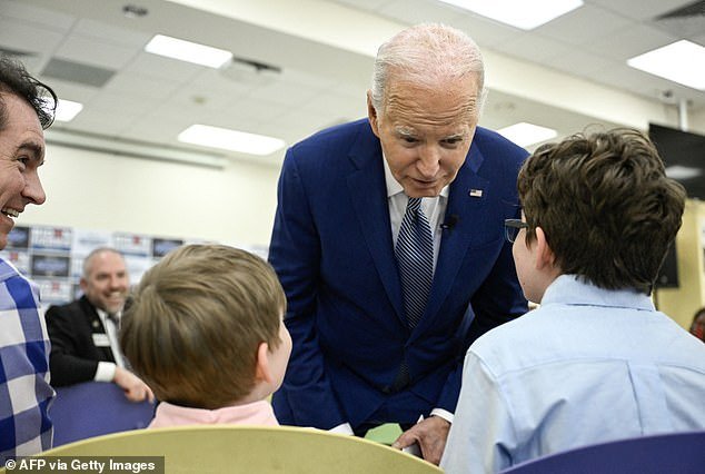US President Joe Biden speaks to two children during a meeting with campaign volunteers and supporters