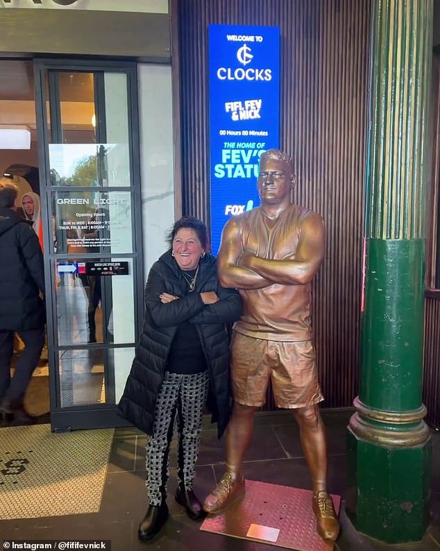 The bronze statue of the former AFL player, 43, now stands next to Clocks Cafe in the concourse.  A home for the statue was sought after it was removed from its original position in Narre Warren.  Pictured: a fan with the Fevola statue