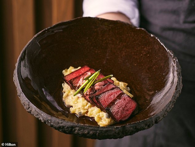 Pictured is a charcoal-grilled ox heart with potato skin risotto and pickled magnolia petals, served at the Hilton London Metropole