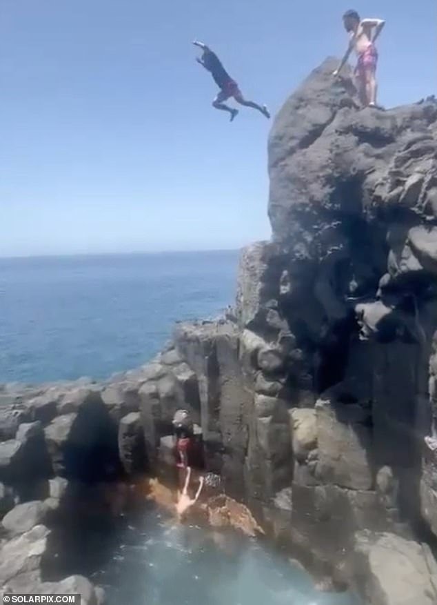 A group of men believed to be friends of the holidaymaker counted down from five before launching themselves into the air