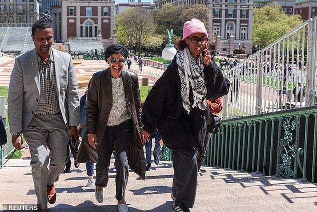 Rep. Ilhan Omar, D-Minn., (center) walks on the campus of Columbia University with her recently suspended daughter Isra Hirsi (right)