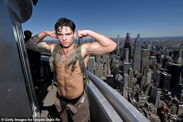 A shirtless Garcia poses on top of the Empire State Building.  It is not clear why his pants are loose