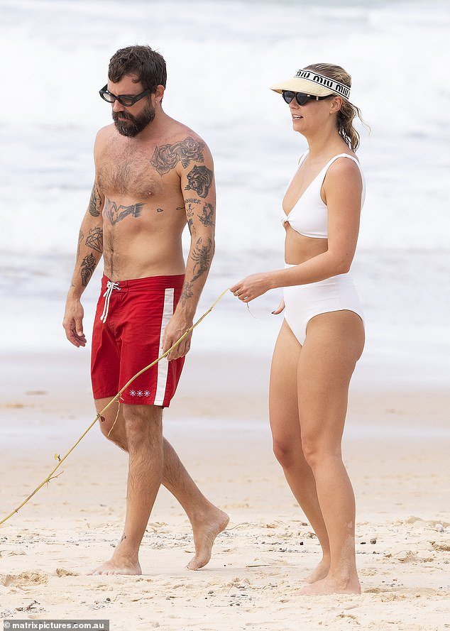 On Friday, the newly single blonde, 32, was all smiles as she hit the beach in Noosa, QLD, with her new male boyfriend, fashion designer Matty Bouris (left).