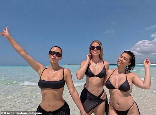 Kim Kardashian, 43, took to Instagram on Thursday to celebrate her sister Kourtney's 45th birthday with a bikini photo of her with Kourtney and younger sister Khloe, 39, leaving fans divided