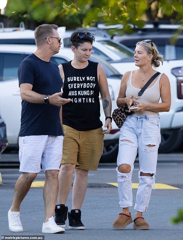 The Rogue Traders singer was spotted strolling with her non-binary lover in Queensland on Saturday as the pair ran errands with a male friend (left)