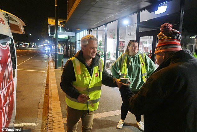 Channel 7 star Nathan Templeton hands out a hot drink to a homeless man on the streets of Geelong