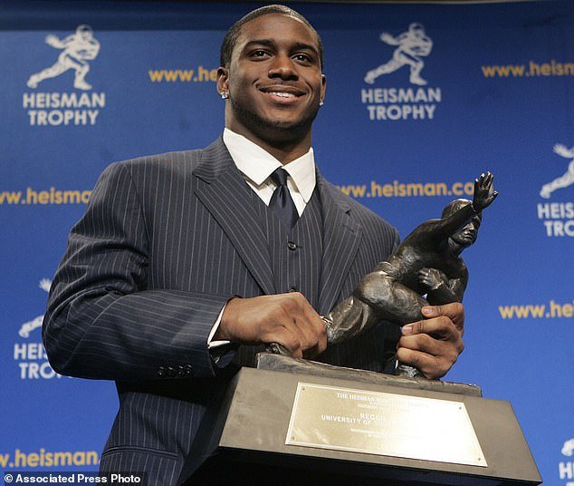 USC's Reggie Bush laughs with the Heisman Trophy during a press conference in 2005
