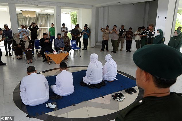 Acehnese couples receive a religious lecture before being caned in front of the public for violating Sharia law, in Banda Aceh, Indonesia