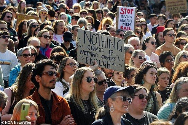 Protesters are pictured marching in solidarity during the 'No More!'  National meeting against violence in Melbourne