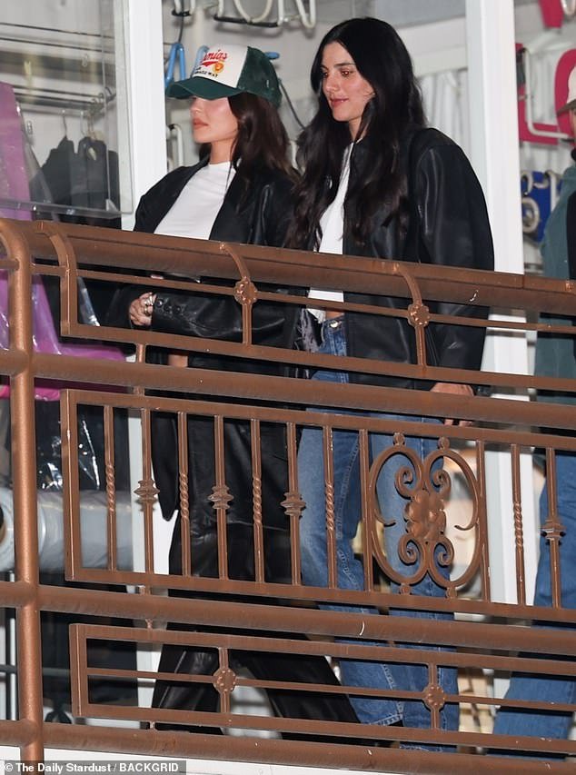 Kylie bundled up with an oversized black leather trench coat