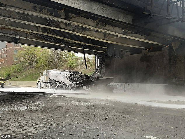 The aftermath of the crash with the remains of the tanker truck pictured beneath the smoldering overpass
