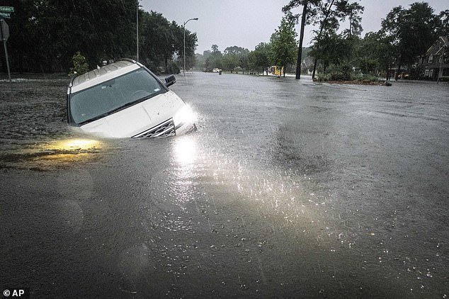 An SUV is seen almost completely submerged in floodwaters in Spring, Texas, on Thursday