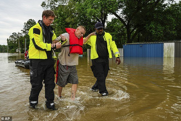A man is rescued by community firefighters in New Caney, Texas on Friday