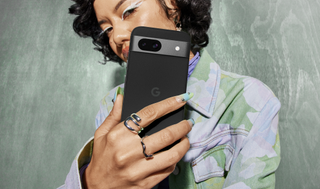 an image of a woman holding an Obsidian Google Pixel 8a
