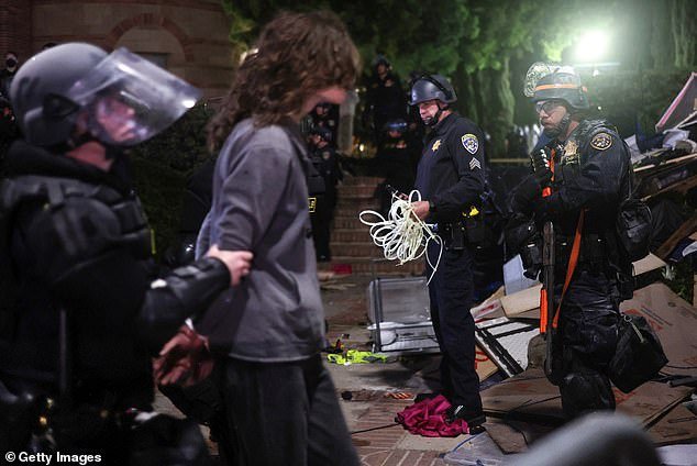 The clash was the latest example of unrest following Gaza solidarity demonstrations on campuses.  Pictured: California Highway Patrol (CHP) officers detain a protester as they clear a pro-Palestinian camp after a dispersal order was issued at UCLA on May 2, 2024