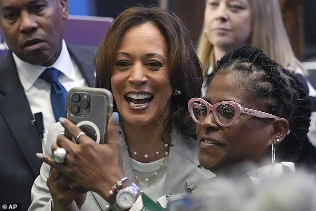 Vice President Kamala Harris, left, takes a selfie photo with a supporter
