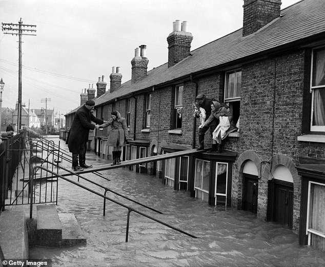 The barrier was caused by the 1953 North Sea flood, which claimed 326 lives on land when it struck the east coast of Britain.  Pictured are residents of Whitstable, Kent