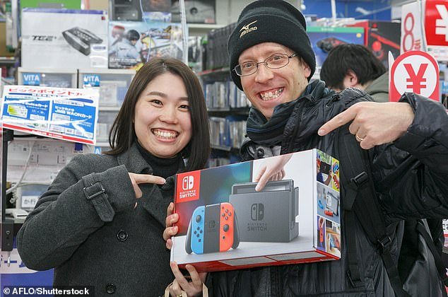 Fans show off their new Nintendo Switch console at consumer electronics store Bic Camera in Tokyo, Japan, March 3, 2017