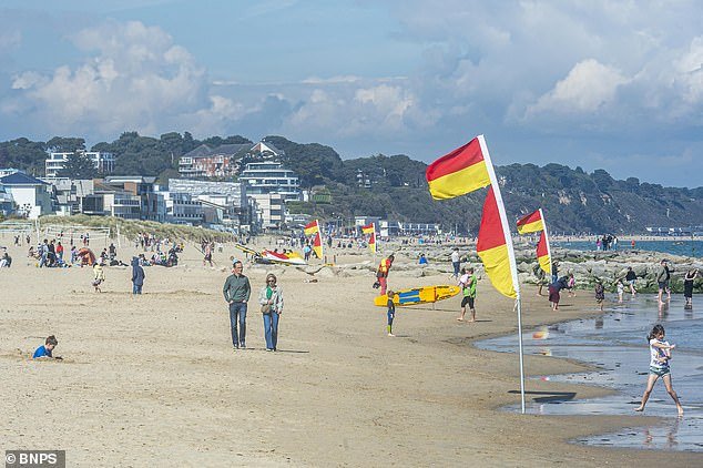 People enjoy a warm and sunny day out at the beach in Sandbanks, Dorset over the bank holiday weekend