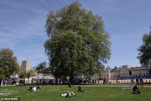 People bask in the sun in St. James's Park in London, May 8, 2024