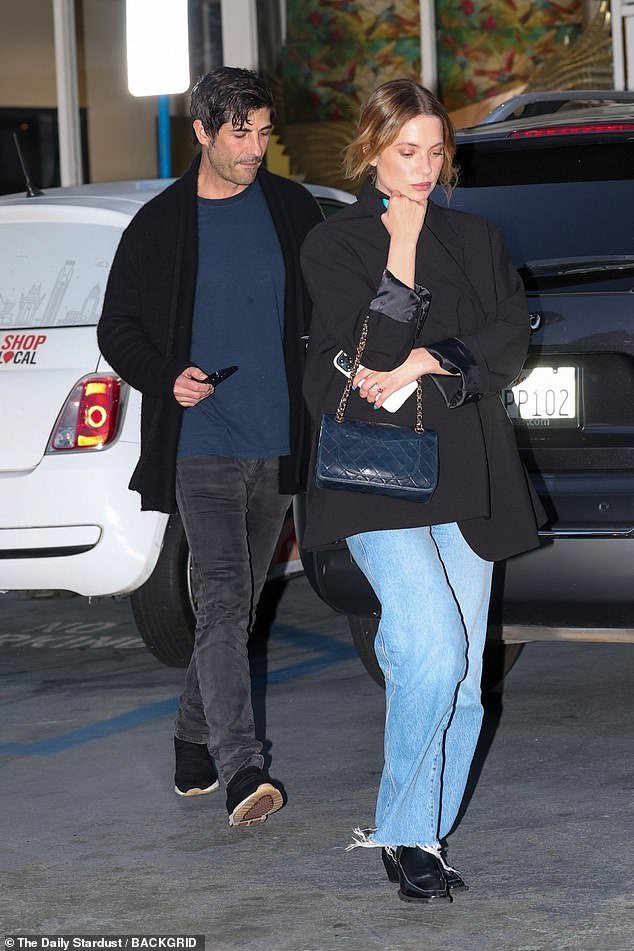 She paired the look with a navy blue bag and sneakers as she held her husband's hand on her way out