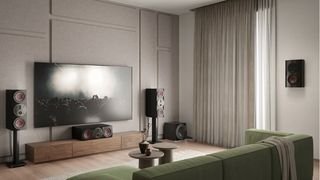 Three Rubikore Cinema speakers and a Rubikore On-Wall speaker, surrounding a TV in a beige sitting room