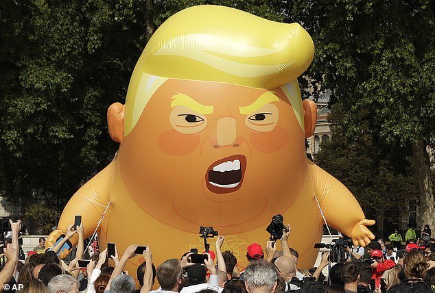 The huge inflatable features the US president in a diaper and holding a mobile phone