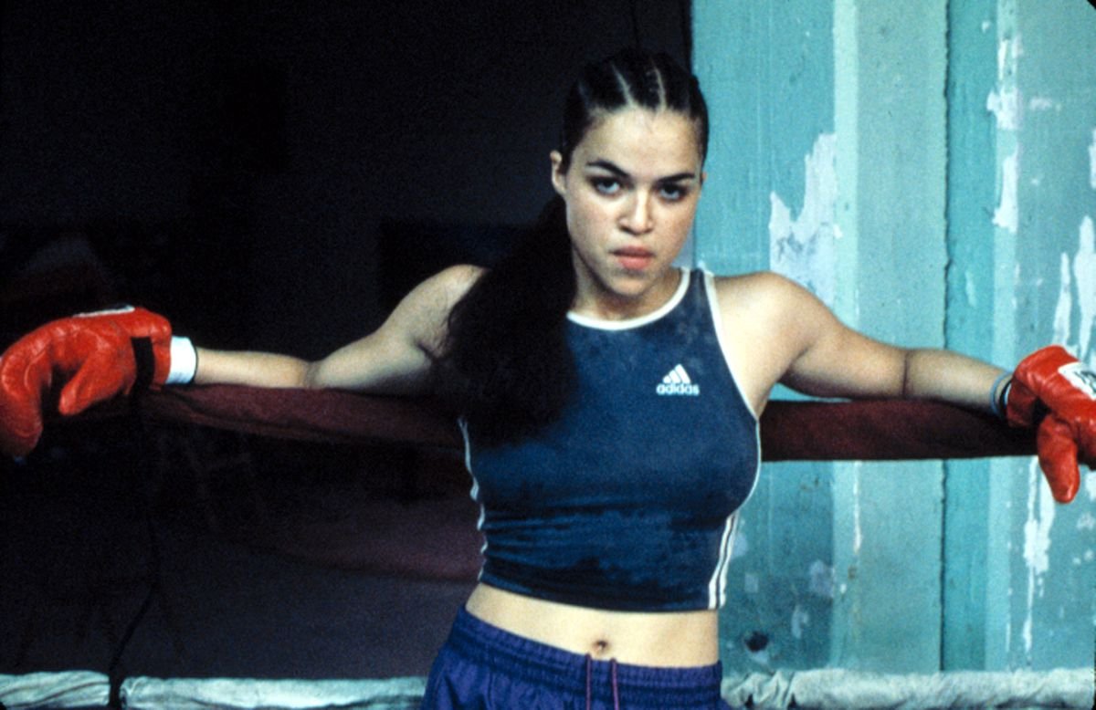 Michelle Rodriguez leans against the edge of a boxing ring