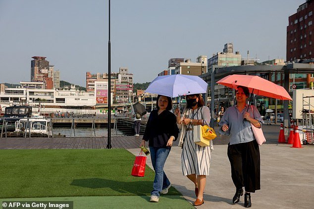 April was the warmest month on record in the world - and the eleventh consecutive record month in a row, new figures show.  Pictured: People hold umbrellas during a heat wave in Taiwan on April 29