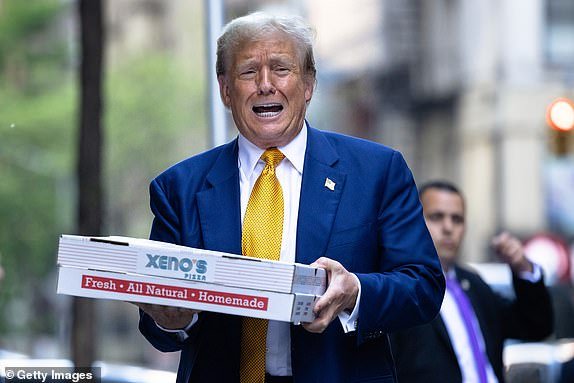 NEW YORK, NEW YORK - MAY 2: Republican presidential candidate, former US President, Donald Trump carries boxes of pizza in front of the FDNY Engine 2, Battalion 8 fire station on May 2, 2024 in New York City.  Trump delivered pizza to a fire station after a court appearance in his hush-money trial, which began with a hearing in which prosecutors argued that Judge Juan Merchan should again charge Trump with criminal contempt for violating a silence order.  Earlier this week, Trump was charged with contempt for nine violations of his April 1 order banning criticism of witnesses and jurors.  (Photo by Michael M. Santiago/Getty Images)